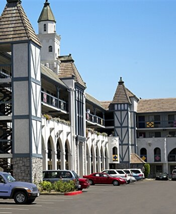 A large white building with a parking lot in front of it.